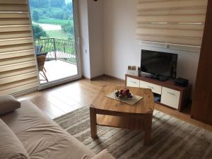 a living room with a couch and a table with a television at Ammirevole -MOON- Apartment in Visoko