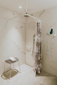 een badkamer met een douche en een tafel. bij Hotel Jerom in Kalmthout