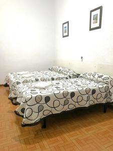 un grupo de 3 camas en una habitación en Hostal Los Arcos, en Madrid