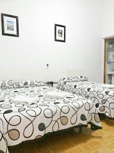 A bed or beds in a room at Hostal Los Arcos