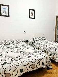 A bed or beds in a room at Hostal Los Arcos