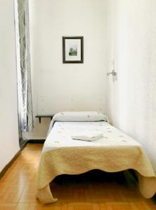 A bed or beds in a room at Hostal Los Arcos