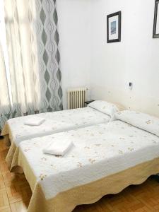 A bed or beds in a room at Hostal Los Arcos
