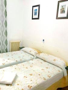 A bed or beds in a room at Hostal Los Arcos