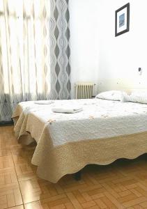A bed or beds in a room at Hostal Los Arcos