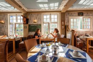 two women sitting at tables in a restaurant at Boat Hotel De Barge in Bruges +31 photos