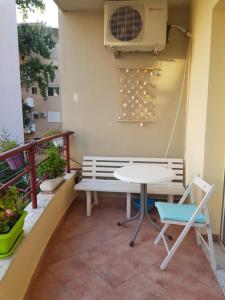 a patio with a table and a bench on a balcony at Apartament Joni in Golem