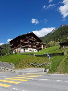 a building on a hill next to a road at Alpen-Sonne in Sankt Niklaus
