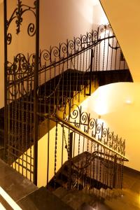 a staircase with a black wrought iron railing at Hotel Boutique Gareus in Valladolid