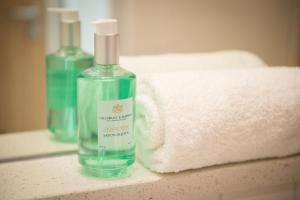 a bottle of soap sitting on a counter next to a towel at West Court- Jesus College in Cambridge +37 photos