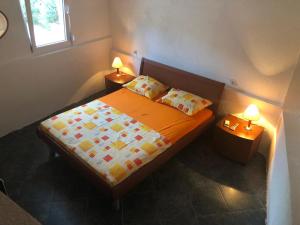 een slaapkamer met een bed met twee lampen op twee tafels bij Apartmani Pavicevic in Podgorica