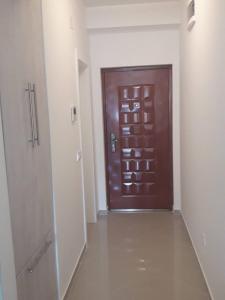 a hallway with a brown door in a room at Apartman Nina in Bar