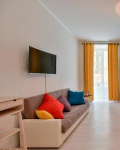un soggiorno con divano e cuscini colorati di Tasso Apartment a Salerno