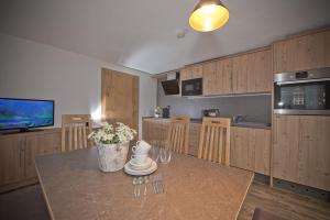 a kitchen with wooden cabinets and a table with wine glasses at Haus Notburga in Serfaus