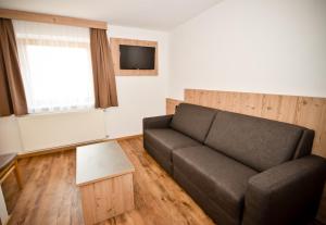 a living room with a couch and a tv at Haus Notburga in Serfaus