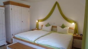 a bedroom with a white bed with a wooden headboard at Ferienwohnung Baltic Sea in Börgerende-Rethwisch