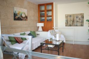 - un salon avec un canapé blanc et une table dans l'établissement Atico Amistad, à Séville