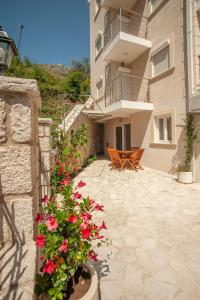 a building with a patio with flowers in front of it at Apartments Dzaleta in Sveti Stefan
