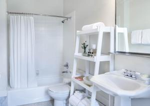 a white bathroom with a toilet and a sink at Inn at Carnall Hall in Fayetteville