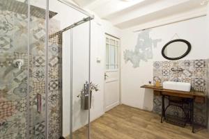 ein Bad mit einer Dusche, einem Waschbecken und einem Spiegel in der Unterkunft Artisan Maison in Palermo