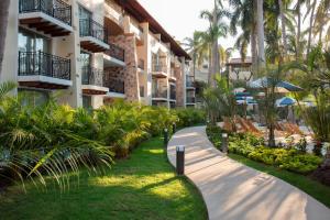 a walkway in front of a building with palm trees at The Hacienda at Krystal Grand Puerto Vallarta- All Inclusive in Puerto Vallarta