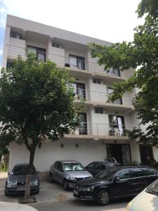 a building with cars parked in front of it at Vila RAZA - locatie centrala in Eforie Nord