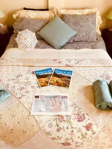 a bed with a comforter with magazines and a newspaper at Treasure Box Retreat in Clifden +11 photos