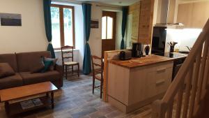 a kitchen and living room with a couch and a table at Le Marite in Sartilly