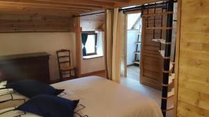 ein Schlafzimmer mit einem Bett und einer Leiter zum Fenster in der Unterkunft Le Marite in Sartilly