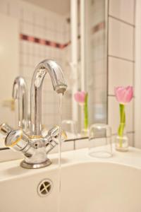 a kitchen sink with water coming out of a faucet at Altstadthotel Bad Griesbach in Bad Griesbach