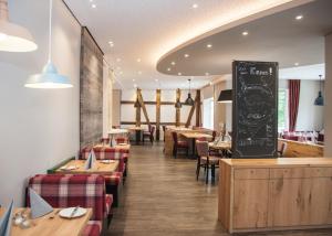 a restaurant with tables and chairs and a chalkboard at Hotel Hessenhof in Winterberg