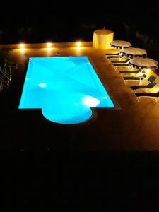 una piscina por la noche con sillas y una mesa en Barone GR Macrì Agriturismo Modi en Gerace