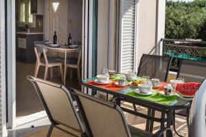 a table on a balcony with a meal on it at Esmeralda Zante House in Argasi