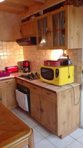 un four micro-ondes jaune assis au-dessus d'un comptoir de cuisine dans l'établissement Gite de charme au coeur de la Bourgogne, à Santigny