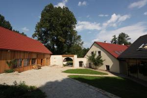 a house with a red roof and a courtyard at Penzion Mlyn Trestice in Třeštice