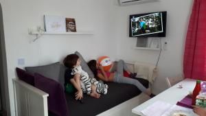dos niños sentados en un sofá viendo una televisión en Apartment Robić en Vir