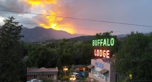een gebouw met een bord dat buffelhut leest bij zonsondergang bij Buffalo Lodge Bicycle Resort - Amazing access to local trails & the Garden in Colorado Springs
