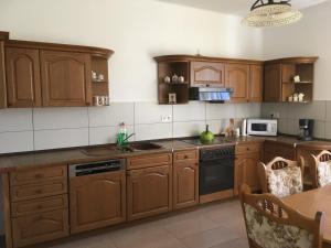 a kitchen with wooden cabinets and a table at Kovács apartman in Balatonberény