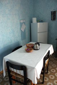 a table with a white table cloth on it with a refrigerator at Patty green house in Castellana Grotte
