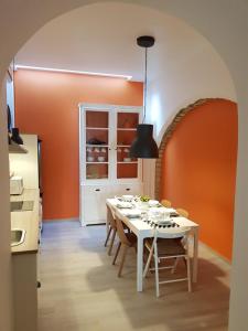 a dining room with a white table and an orange wall at Casa Da Ponte in Estói