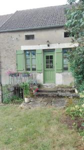 una casa con una puerta verde y un patio en Gite de charme au coeur de la Bourgogne, en Santigny