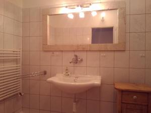 a white bathroom with a sink and a mirror at Pension Baron Schoeneck in Karlovy Vary