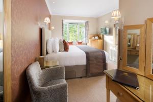 a bedroom with a bed and a desk and a chair at Cedar Manor in Windermere