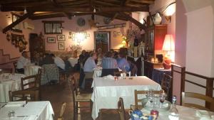 フィシャーノにあるLocanda della Bottegaのレストランの席に座る人々