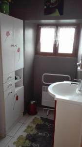 baño con lavabo blanco y ventana en Gite de charme au coeur de la Bourgogne, en Santigny