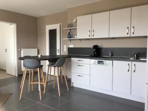 a kitchen with white cabinets and a black counter top at Residence Belle Epoque in Wimereux +20 photos