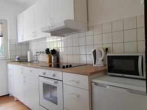 ゲルゼンキルヒェンにあるApartment-Schlosshorst 1のキッチン(白いキャビネット、電子レンジ付)