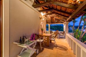 a patio with a table and chairs on a balcony at Villa Fortica in Milna