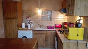 una pequeña cocina con fregadero y microondas amarillo en Gite de charme au coeur de la Bourgogne, en Santigny