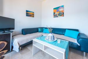 a living room with a blue couch and a table at Bace Apartments in Klek